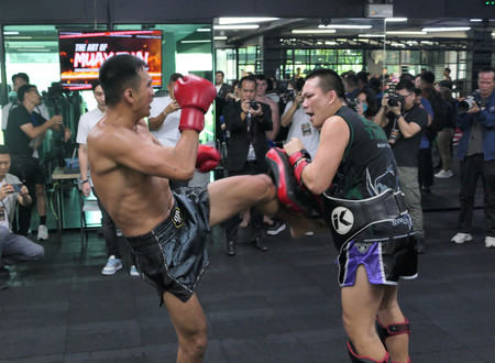 格闘技ムエタイを披露するタイのプロ選手（左）＝３月２２日、バンコク