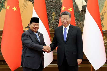 １日、北京の人民大会堂で握手するインドネシアのプラボウォ次期大統領（左）と中国の習近平国家主席（ロイター時事）