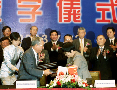 合弁生産調印式で握手する新日本製鉄の千速晃会長（左）と上海宝山鋼鉄の謝企華会長（肩書はいずれも当時）＝２００３年７月、中国・上海