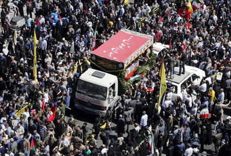 ５日、イランの首都テヘランで、シリアで殺害された精鋭組織「革命防衛隊」の隊員らのひつぎを乗せたトラックの周りに集まる人々（ＥＰＡ時事）