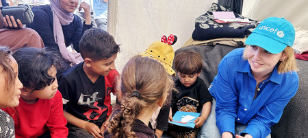 パレスチナ自治区ガザの最南部ラファで、子どもたちと交流する国連児童基金（ユニセフ）のテス・イングラム報道官（右端）＝３日（日本ユニセフ協会提供）
