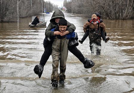 ８日、ロシア・オレンブルク州オルスクで、救助される洪水被災者（ＡＦＰ時事）