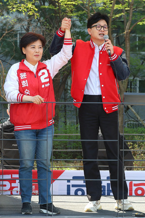 ９日、ソウルで有権者に支持を訴える韓国与党「国民の力」トップの韓東勲非常対策委員長（右）（ＥＰＡ時事）