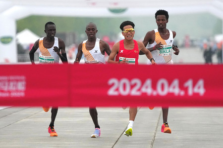 北京ハーフマラソンでゴールする何傑（左から３人目）ら＝１４日（ロイター時事）