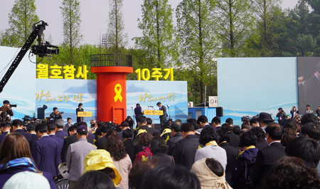 １６日、ソウル近郊・安山市で、旅客船セウォル号の沈没事故から１０年を迎え、追悼集会で黙とうする出席者ら