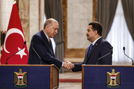 ２２日、バグダッドで握手するトルコのエルドアン大統領（左）とイラクのスダニ首相（ＡＦＰ時事）