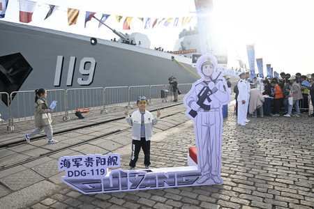 一般公開された中国軍のミサイル駆逐艦「貴陽」の前で写真を撮る子供＝２０日、山東省青島（ＡＦＰ時事）