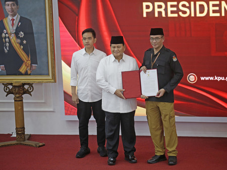２４日、ジャカルタの総選挙委員会で撮影に応じるインドネシアのプラボウォ次期大統領（中央）（ＥＰＡ時事）