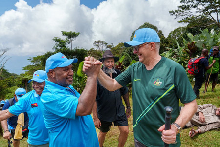 ２４日、パプアニューギニアでマラペ首相（左）と手を組むアルバニージー豪首相（豪首相府提供・時事）