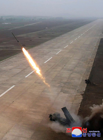 ２５日に北朝鮮で行われた２４０ミリの多連装ロケット砲の試射＝撮影場所不明（朝鮮通信・時事）