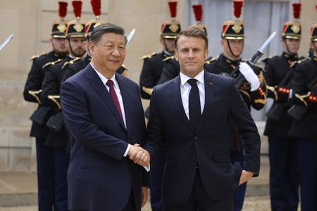 ６日、パリのエリゼ宮（大統領府）で中国の習近平国家主席（左）を迎えるマクロン仏大統領（ＥＰＡ時事）
