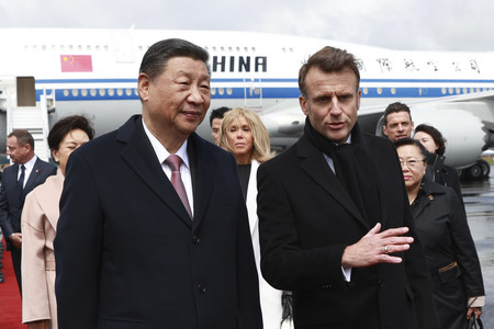 ７日、フランス南西部オートピレネー県の空港で中国の習近平国家主席（手前左）を歓迎するマクロン大統領（同右）（ＥＰＡ時事）