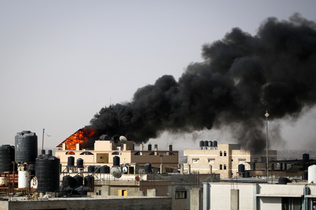 １０日、パレスチナ自治区ガザ最南部ラファで、イスラエル軍の攻撃を受け、黒煙が立ち上る建物（ＡＦＰ時事）