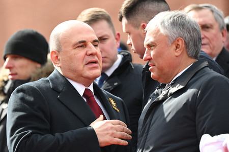 ９日、モスクワの「赤の広場」で、言葉を交わすロシアのミシュスチン首相（左）とウォロジン下院議長（ＡＦＰ時事）