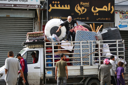 １１日、パレスチナ自治区ガザ最南部ラファで、避難するため家財道具をトラックに積み込む市民（ＡＦＰ時事）