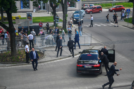 １５日、スロバキアのハンドロバで、銃撃されたフィツォ首相を車に乗せる警護要員（ロイター時事）