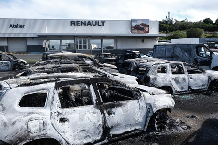 フランス領ニューカレドニアの中心都市ヌメアの自動車販売店で、燃やされ放置された車＝１４日（ＡＦＰ時事）