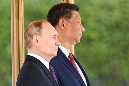 １６日、北京で開かれた歓迎式典で肩を並べる中国の習近平国家主席（奥）とロシアのプーチン大統領＝同国大統領府提供（ＡＦＰ時事）