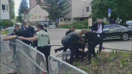 スロバキア中部ハンドロバで、銃撃されたフィツォ首相の両脇を抱えて車に運ぶ警護官＝１５日（ＡＦＰ時事）