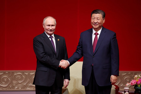握手するロシアのプーチン大統領（左）と中国の習近平国家主席＝１６日、北京（ＥＰＡ時事）