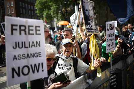 英高等法院の外で気勢を上げるジュリアン・アサンジ被告の支援者ら＝２０日、ロンドン（ＡＦＰ時事）