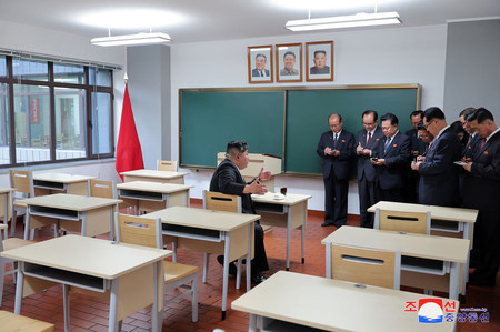 ２１日、竣工（しゅんこう）した平壌の朝鮮労働党中央幹部学校の教室を視察する金正恩総書記（左端）（朝鮮通信・時事）