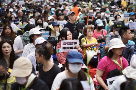 ２４日、台北でプラカードを掲げる台湾の与党・民進党の支持者ら（ＡＦＰ時事）