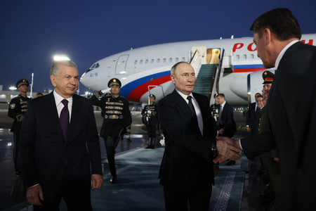 ２６日、ウズベキスタンの首都タシケントの空港に到着したロシアのプーチン大統領（中央）（ＡＦＰ時事）