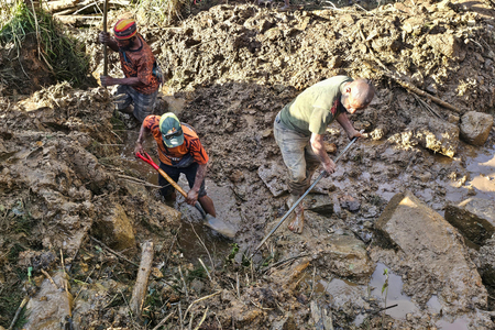 パプアニューギニア中部エンガ州の村の地滑り現場でがれきの山を掘り返す人たち＝２７日（ＡＦＰ時事）