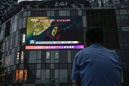 中国軍が台湾を取り囲んで実施した軍事演習についてのニュースを映した屋外モニター＝２３日、北京（ＡＦＰ時事）