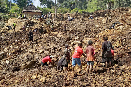 ３０日、パプアニューギニア・エンガ州の地滑り現場で捜索活動を行う人々（ＡＦＰ時事）