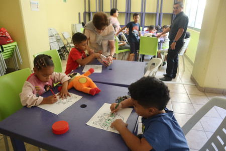 保護施設内で塗り絵をする米国への移民希望者の子ども＝５月３０日、メキシコ市