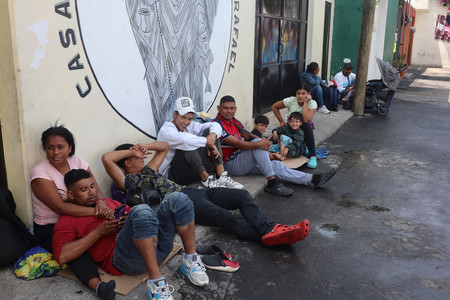 保護施設に入り切れず、敷地の外で過ごす米国への移民希望者ら＝５月３０日、メキシコ市
