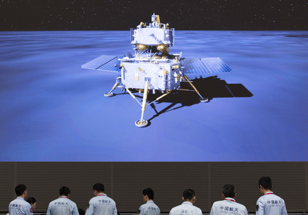 ２日、北京にある管制センターのモニターに映し出された中国の無人探査機「嫦娥６号」の着陸イメージ画像を前に作業する技術者ら（ＥＰＡ時事）