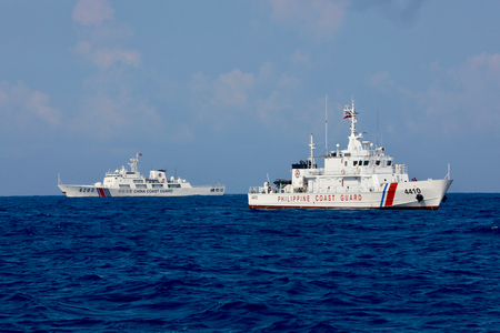 南シナ海の海上を接近して進む中国海警局の船舶（左）とフィリピン沿岸警備隊の船舶＝５月１６日（ＥＰＡ時事）