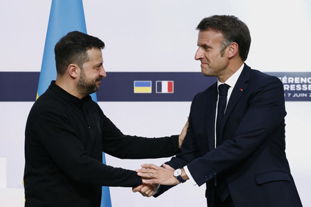 ７日、パリで握手を交わすウクライナのゼレンスキー大統領（左）とフランスのマクロン大統領（ＡＦＰ時事）