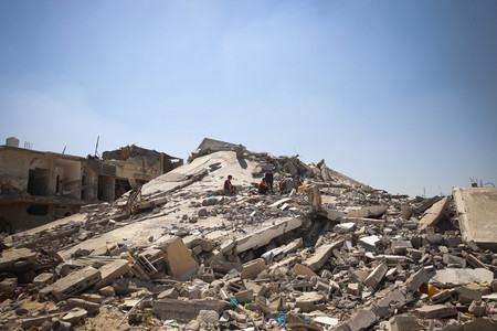 １１日、パレスチナ自治区ガザ南部ハンユニスで、イスラエル軍の攻撃によってがれきと化した建物（ＡＦＰ時事）