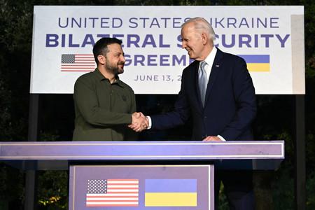 １３日、イタリア南部プーリア州で、握手するウクライナのゼレンスキー大統領（左）とバイデン米大統領（ＡＦＰ時事）