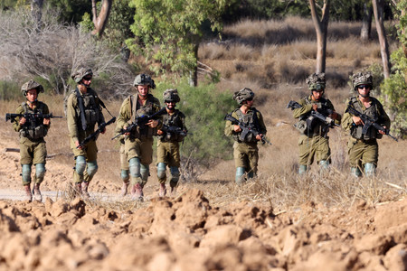 １３日、パレスチナ自治区ガザとの境界地帯に展開するイスラエル軍兵士（ＡＦＰ時事）