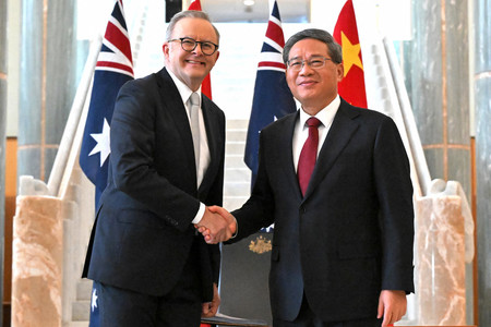 １７日、キャンベラの国会議事堂で握手するオーストラリアのアルバニージー首相（左）と中国の李強首相（ＡＦＰ時事）