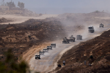 １７日、パレスチナ自治区ガザで展開するイスラエル軍の車列（ロイター時事）