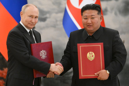 １９日、平壌で新条約に署名後、握手を交わすロシアのプーチン大統領（左）と北朝鮮の金正恩朝鮮労働党総書記（ＡＦＰ時事）