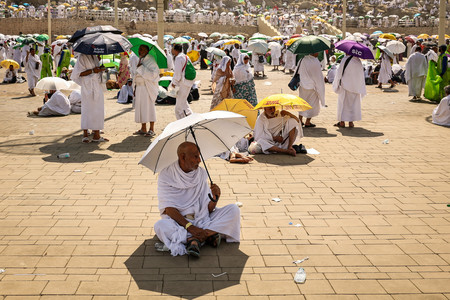 傘を差すイスラム教徒の巡礼者＝１５日、サウジアラビア西部メッカ近郊（ＡＦＰ時事）