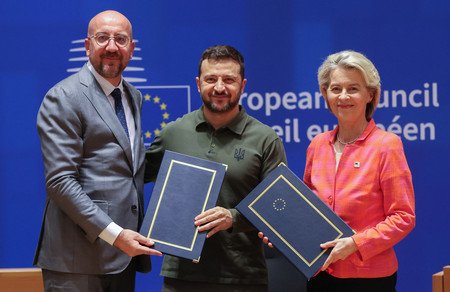 ２７日、ブリュッセルで行われた安保協定の署名式に臨むウクライナのゼレンスキー大統領（中央）と欧州連合（ＥＵ）のミシェル大統領（左）、フォンデアライエン欧州委員長（ＡＦＰ時事）