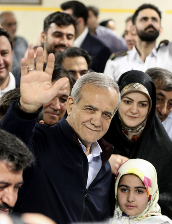 ２８日、テヘランで、イラン大統領選の投票所に到着した改革派のペゼシュキアン元保健相（中央）（ＥＰＡ時事）