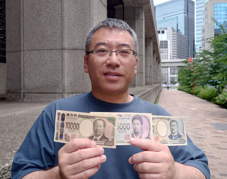 日銀本店で手に入れた新紙幣を見せる会社員男性＝３日午前、東京都中央区の日銀本店前