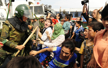 抗議デモに参加し、人民武装警察ともみ合うウイグル族女性たち＝２００９年７月、中国西部、新疆ウイグル自治区の区都ウルムチ（ＡＦＰ時事）