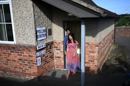 ４日、票を投じ、英中部ノーサラートンの投票所を後にするスナク首相夫妻（ＡＦＰ時事）