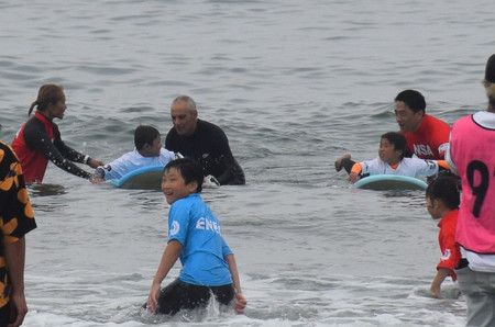 子供らとサーフィンを楽しむエマニュエル駐日米大使（奥左から３人目）と小泉進次郎元環境相（同５人目）＝６日、福島県南相馬市