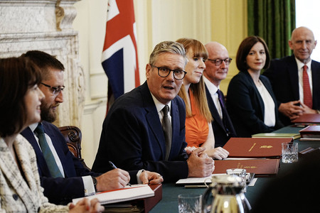 ６日、ロンドンの英首相官邸で初閣議に臨むスターマー首相（左から３人目）（ＡＦＰ時事）